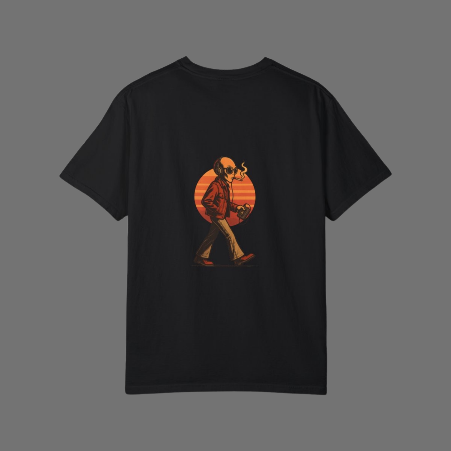 Flat lay of black oversized t-shirt featuring back print of a smoking alien with headphones walking in front of a retro sunset